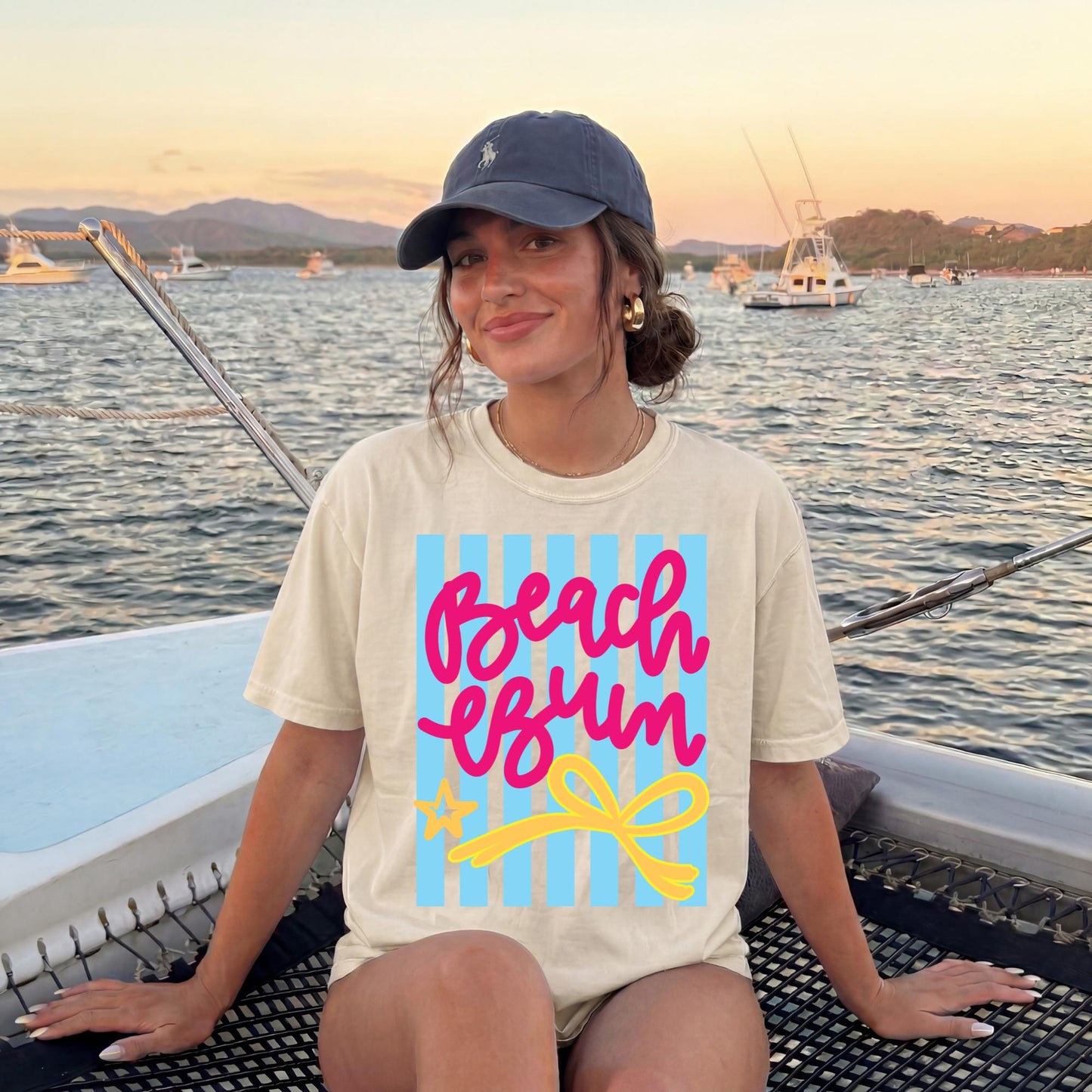 Soft Breathable Fabric Tee Women White Beach Vacation Shirt Pink Script Beach Bum Text Blue Stripe Accent Summer Casual Wear Comfortable Resort Outfit Tropical Trip Clothing Cruise Apparel Essential Poolside Casual Top Relaxed Fit Design