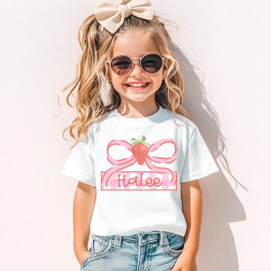 Personalized Strawberry Shirt Toddler Girl Birthday Gift Custom Name Embroidered Clothing Youth Summer Fruit Outfit White Cotton Comfort Tee Pink Bow Design Customizable Name Frame Adorable Graphic Shirt Sizes XSmall Through XL Casual