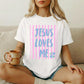 Christian Graphic Tee Women Jesus Loves Me Shirt Faith Based Religious Apparel Inspirational Scripture Message Design Gradient Blue Purple Typography Pink Vertical Stripe Pattern Floral Detail Accent Premium Cotton Fabric Comfort Church